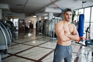 homem árabe em forma e musculoso posando no ginásio. foto