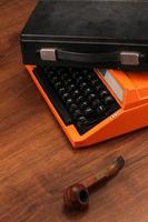 máquina de escrever vintage laranja na madeira