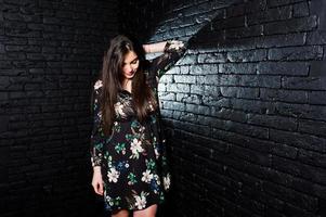 retrato de uma jovem fabulosa em vestido floral no estúdio escuro. foto