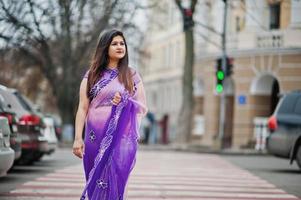 garota hindu indiana no tradicional saree violeta posou na rua, andando na passagem para pedestres. foto