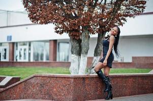 jovem elegante linda afro-americana na rua, vestindo roupa de moda sexy preta. foto