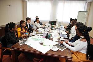 equipe de negócios multirracial abordando a reunião em torno da mesa da diretoria. foto