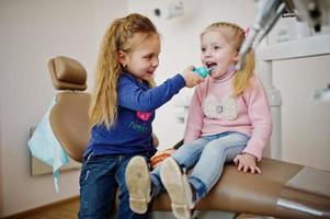 duas garotinhas fofinhas na cadeira do dentista. crianças odontológicas. foto