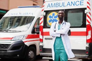 paramédico masculino africano em frente ao carro da ambulância. foto