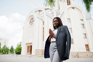 mulher afro-americana ao ar livre contra a igreja e reza a Deus. conceito de fé, espiritualidade e religião.