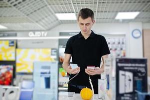 vendedor homem consultor profissional de telefonia móvel na loja de tecnologia ou loja mantenha o novo smartphone à mão. foto