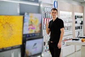 vendedor homem consultor profissional em loja de tecnologia ou loja estande perto de tv inteligente. foto