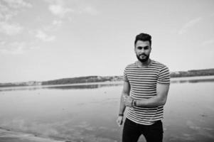 modelo de homem de barba árabe alto bonito na camisa despojada posou ao ar livre. cara árabe na moda. foto