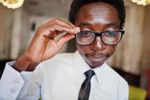 close-up do homem afro-americano de negócios usar camisa branca, gravata e óculos no escritório.