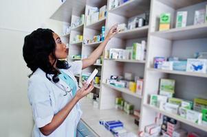 farmacêutico americano africano trabalhando em drogaria na farmácia hospitalar. saúde africana. foto