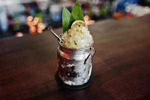 coquetel alcoólico com gelo em vidro de lata na mesa do bar. foto