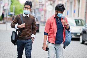 conceito de coronavírus covid-19. dois indianos do sul da Ásia usando máscara para proteger do vírus corona andando na cidade. novo estilo de vida normal pós pandemia na índia. foto
