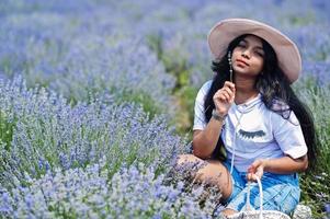 linda garota indiana segura cesta no campo de lavanda roxo. foto