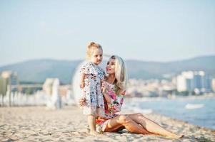 mãe e filha linda se divertindo na praia. retrato de mulher feliz com menina bonitinha de férias. foto