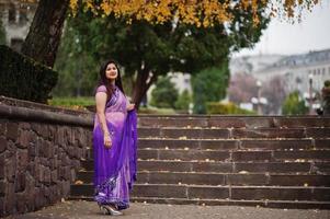 menina hindu indiana no saree violeta tradicional posou na rua de outono. foto