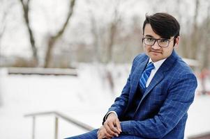 homem de negócios indiano elegante de terno e óculos posou em dia de inverno ao ar livre. foto