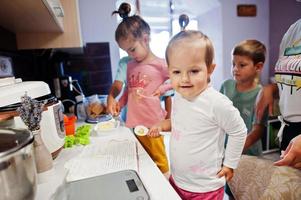 mãe com filhos cozinhando na cozinha, momentos infantis felizes. foto