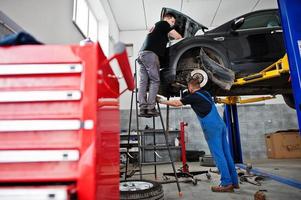 tema de reparação e manutenção de automóveis. mecânico de uniforme trabalhando em auto serviço. foto