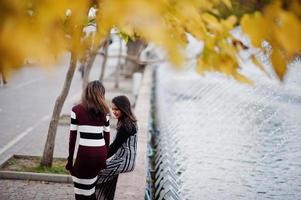 retrato de dois jovens lindos indianos ou adolescentes do sul da Ásia em vestido posou no parque outono. foto