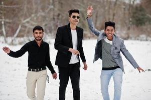 grupo de três casuais jovens indianos posaram em dia de inverno se divertindo e dançando. foto