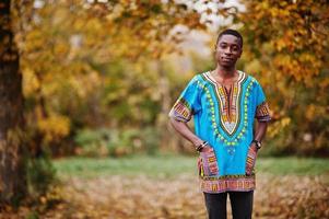 homem africano na camisa tradicional da África no parque outono. foto