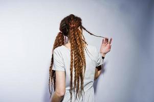 estúdio atirar nas costas da garota de vestido cinza com dreads em fundo branco. foto