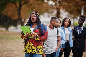 fila do grupo cinco estudantes universitários africanos passando tempo juntos no campus no pátio da universidade. amigos negros afro estudando. tema educação. foto