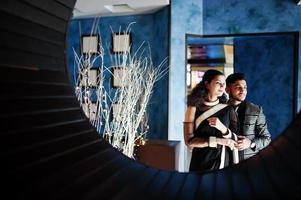 lindo casal indiano apaixonado, veste saree e terno elegante, posou no restaurante no círculo redondo na parede. foto