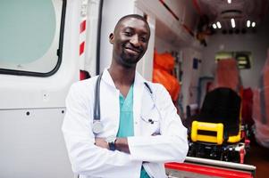 paramédico masculino africano em frente ao carro da ambulância. foto