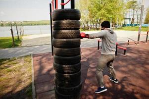 retrato esportivo homem boxer árabe em máscara facial médica preta boxe ao ar livre durante a quarentena de coronavírus. foto