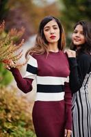 retrato de dois jovens lindos indianos ou adolescentes do sul da Ásia em vestido posou perto de arbustos. foto