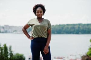 garota africana posou na rua da cidade vestindo blusa verde e calça azul. foto