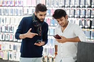 dois índios mans comprador do cliente na loja de celular com eles novos smartphones. conceito de povos e tecnologias do sul da Ásia. loja de celulares. foto