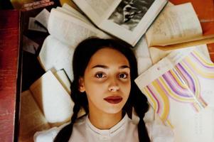 menina com tranças na blusa branca na antiga biblioteca. foto