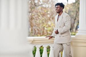 homem afro elegante em terno bege da velha escola. elegante jovem homem africano na jaqueta casual no torso nu. foto