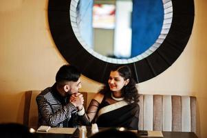 lindo casal indiano apaixonado, veste saree e terno elegante, posou no restaurante. foto