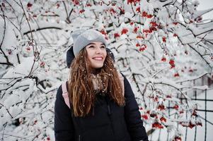 retrato de menina no dia de inverno nevado perto de árvores cobertas de neve. foto