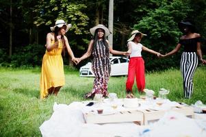 grupo de meninas afro-americanas comemorando festa de aniversário se divertindo e dançando ao ar livre com decoração. foto