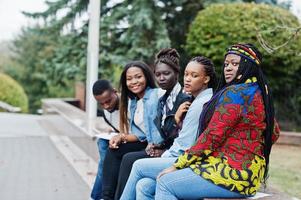 grupo de cinco estudantes universitários africanos passando tempo juntos no campus no pátio da universidade. amigos negros afro estudando. tema educação. foto