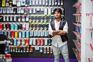 comprador de cliente homem indiano na loja de celulares escolhe uma capa para seu smartphone. conceito de povos e tecnologias do sul da Ásia. loja de celulares. foto