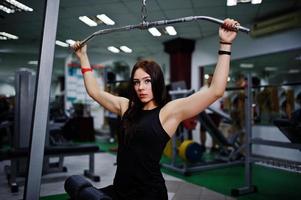 treino de garota esporte jovem no ginásio. mulher fitness fazendo exercícios. foto