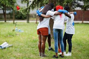 grupo de abraços de voluntários africanos felizes no parque. áfrica voluntariado, caridade, pessoas e conceito de ecologia. foto