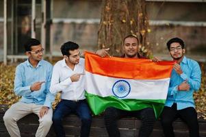 grupo de quatro homens indianos do sul da Ásia com bandeira da índia. foto