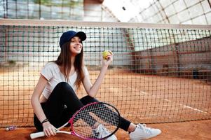 jovem jogador desportivo com raquete de tênis na quadra de tênis. foto