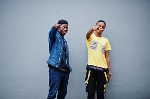 dois amigos de gangsta masculinos africanos mostram os dedos para a câmera. foto