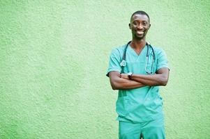 retrato de médico masculino africano com estetoscópio vestindo casaco verde. foto