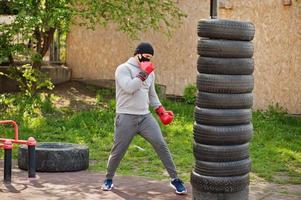 retrato esportivo homem boxer árabe em máscara facial médica preta boxe ao ar livre durante a quarentena de coronavírus. foto