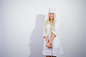 atraente loira médica ou enfermeira no jaleco isolado no fundo branco. foto