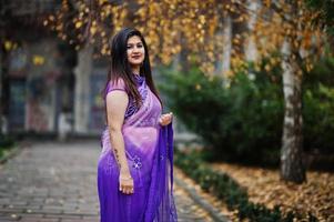 menina hindu indiana no saree violeta tradicional posou na rua de outono. foto