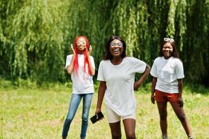 três mulheres afro-americanas no parque em camisetas brancas. foto